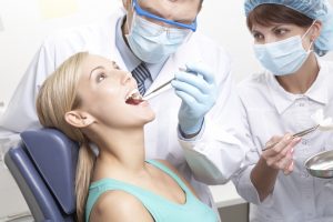 Woman in dental chair with dentist operating on her